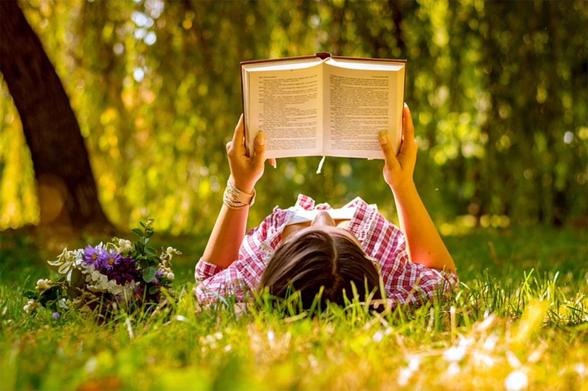 child reading in the grass