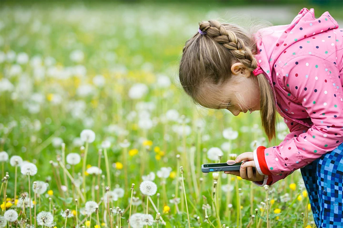 child taking pictures with cell phone