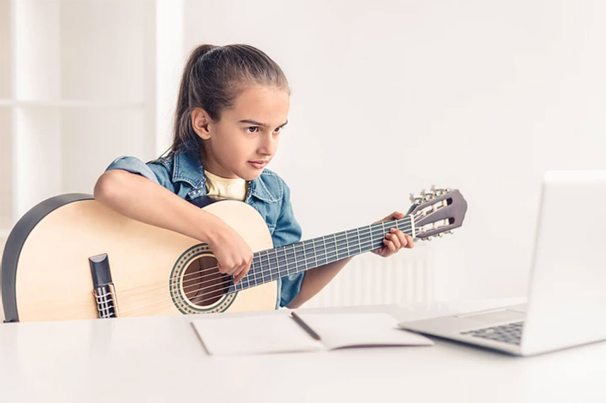 girl learning to play guitar