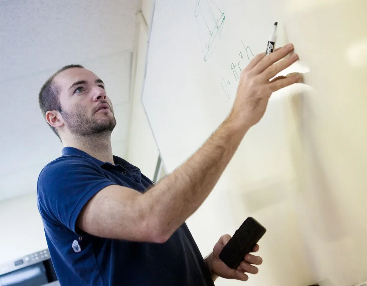 tutor writing on whiteboard